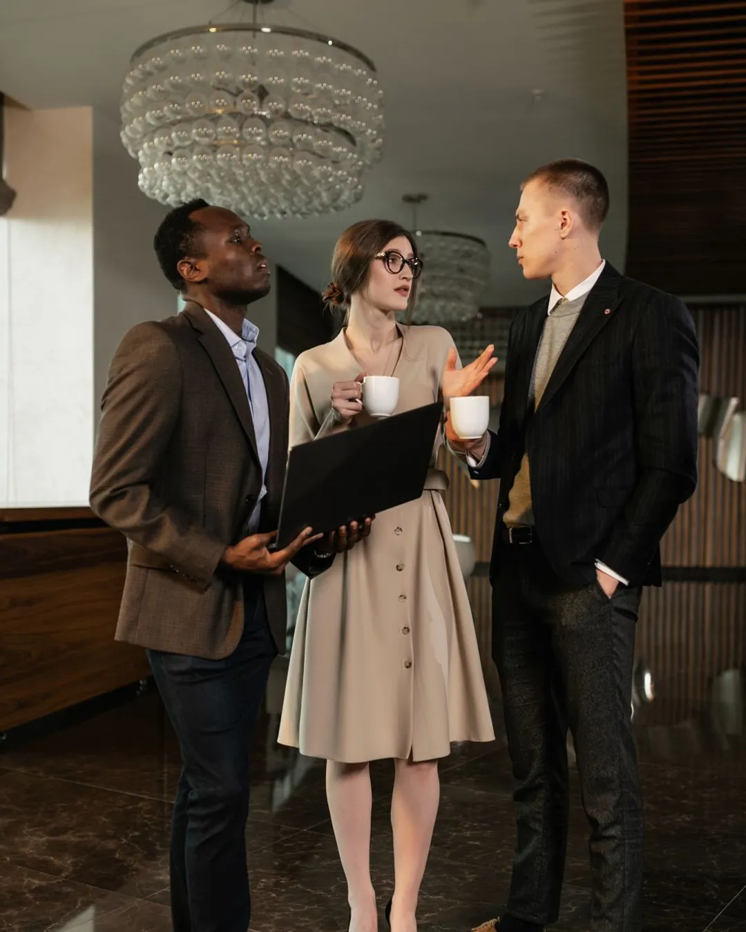 Professionnels en discussion d'affaires autour d'un ordinateur portable, la cible des campagnes LinkedIn Ads B2B